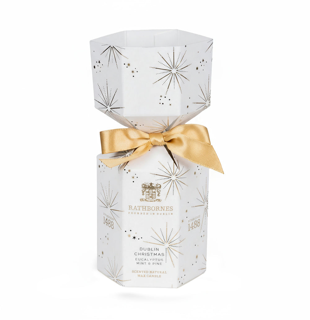 A white hexagonal candle box with golden accents and a bow against a white background.