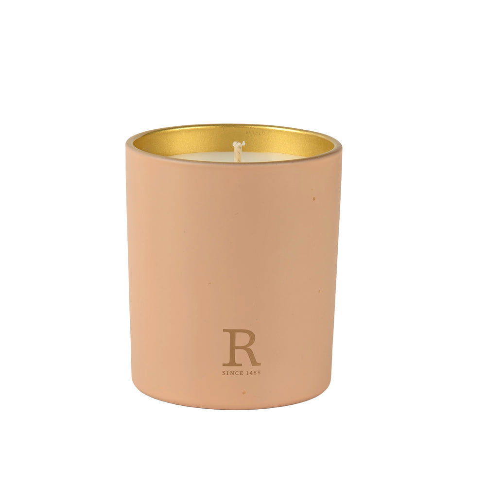 Pink candle with gold accent colour on the inside against a white background
