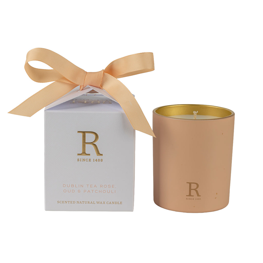 Gold candle with a matching box featuring a bow on a white background