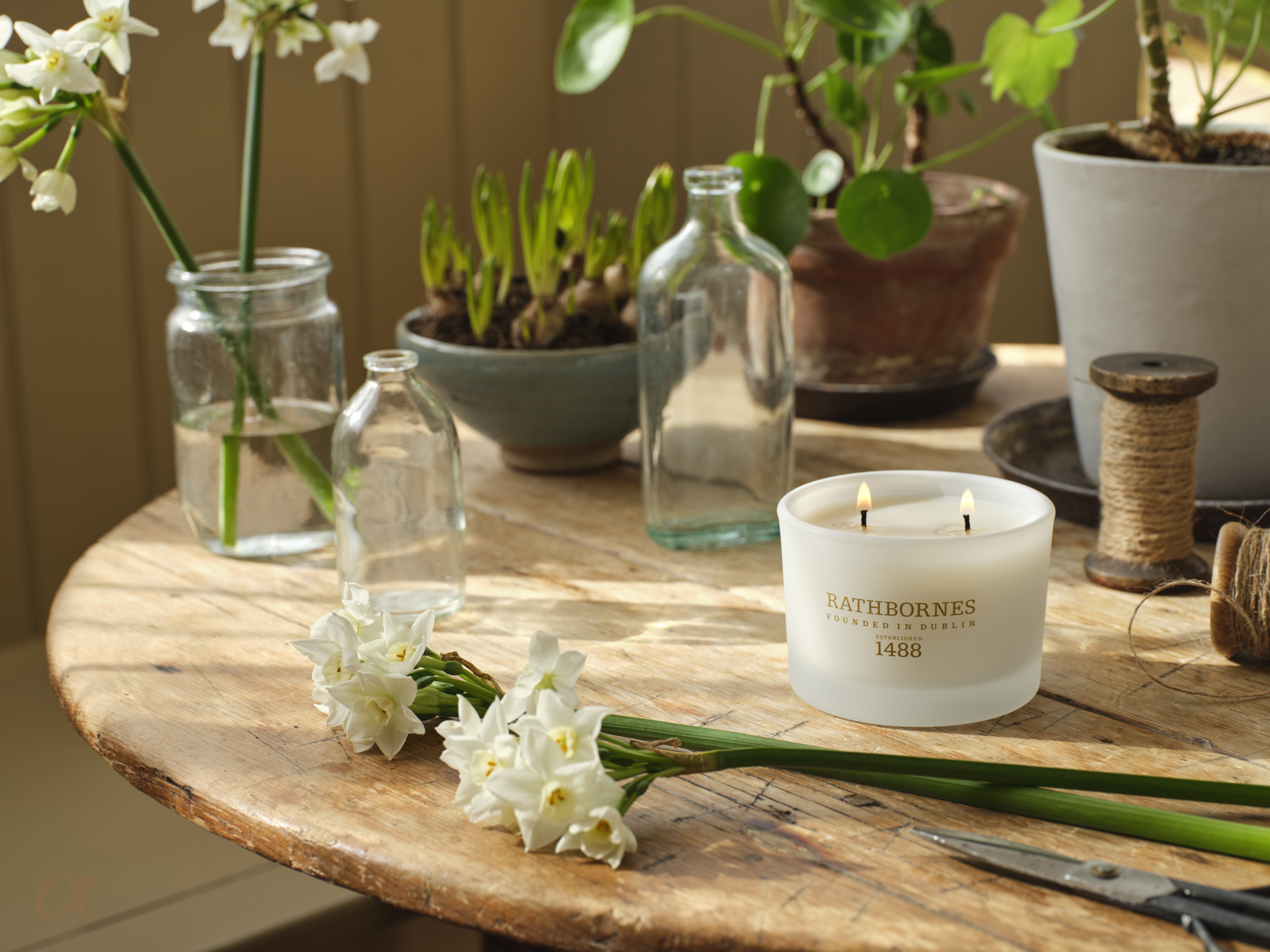 Candle on a wooden table with flowers
