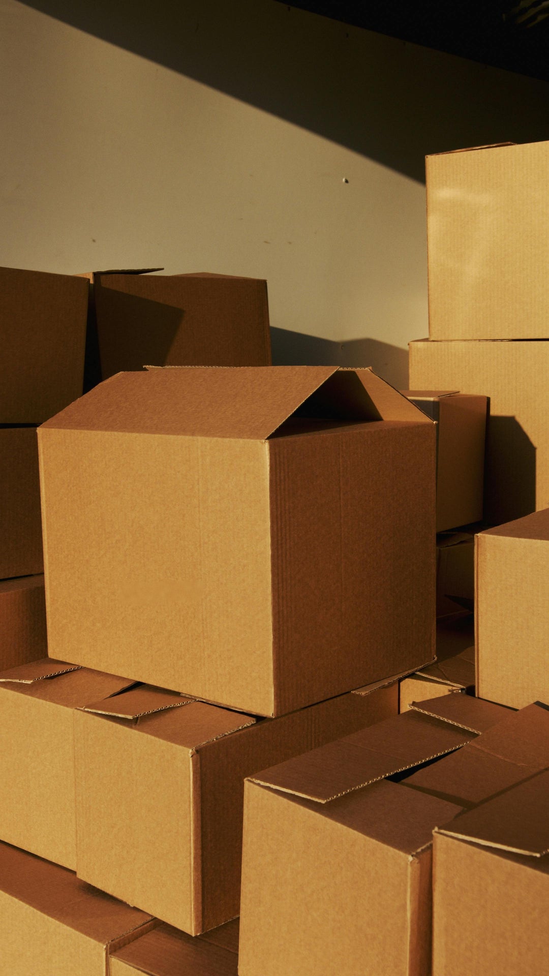 Stack of brown cardboard boxes against a plain background