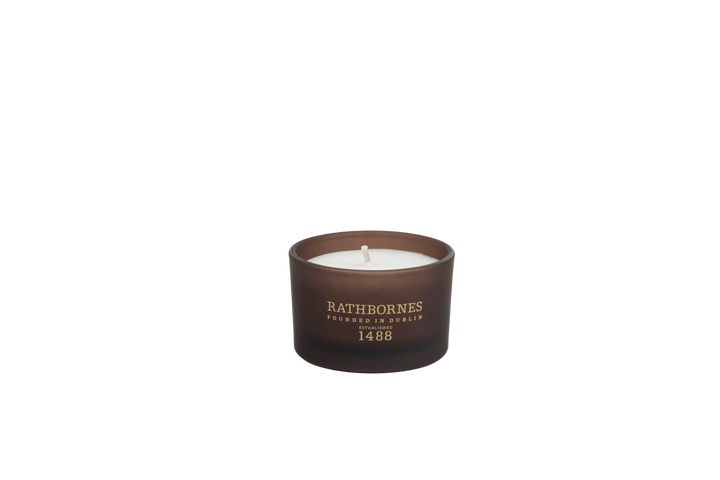 Candle in a brown container with 'Rathborne's' branding with a transparent background