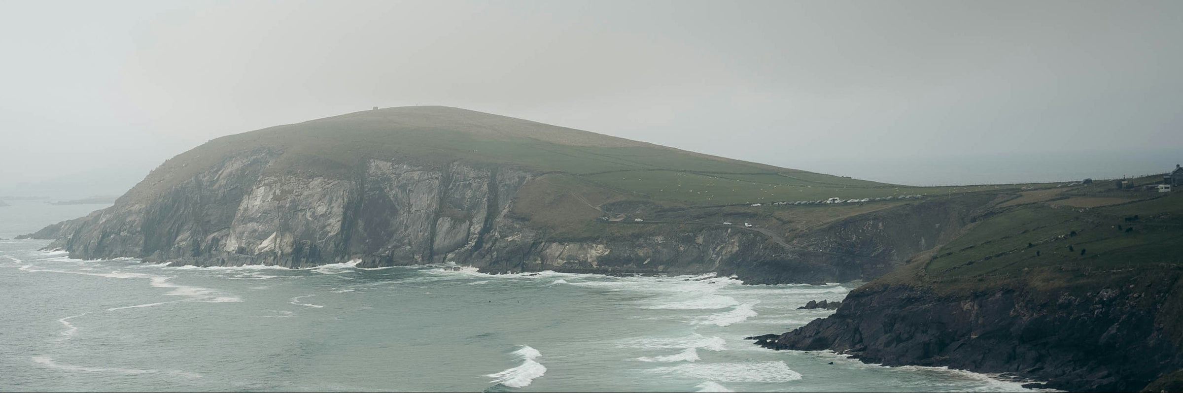 Coastal landscape with cliffs and ocean waves on a foggy day
