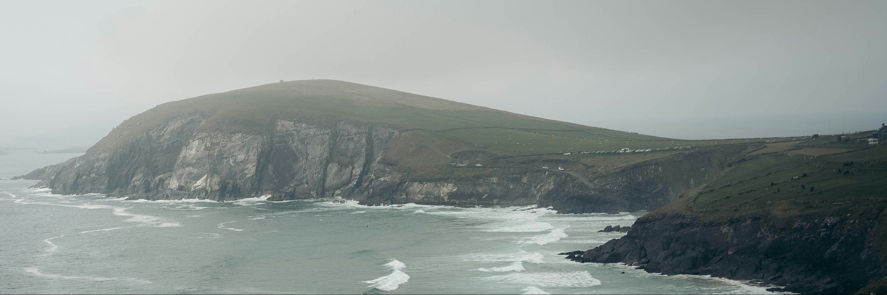 Coastal landscape with cliffs and ocean waves on a foggy day