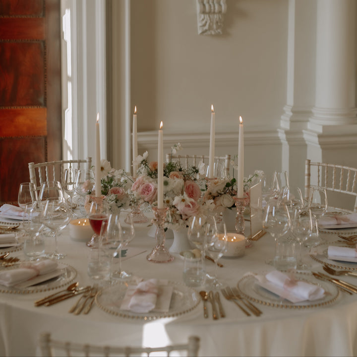 Elegant table setting with floral centerpieces in a formal room.