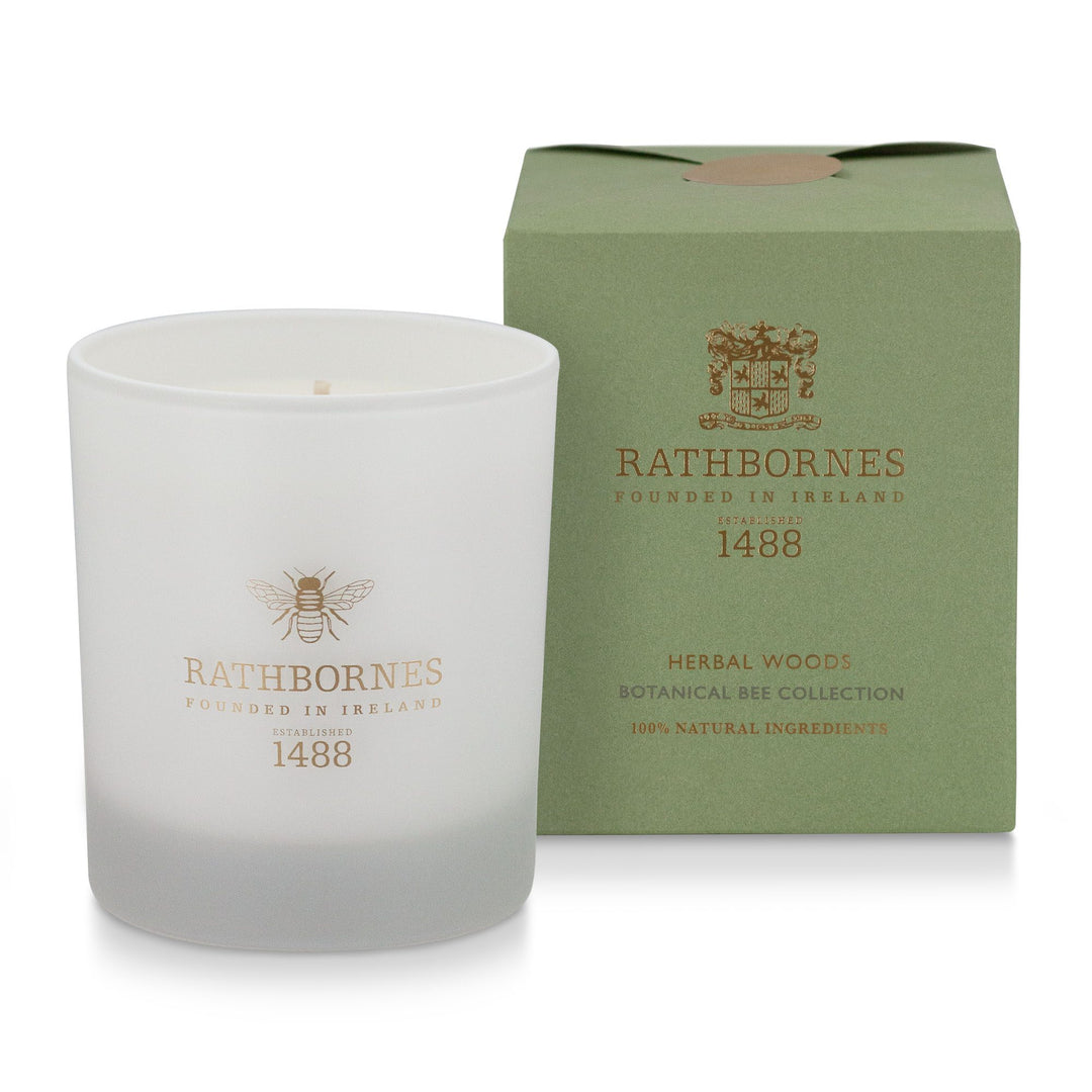 Rathbornes Herbal Woods scented candle beside its sage green gift box