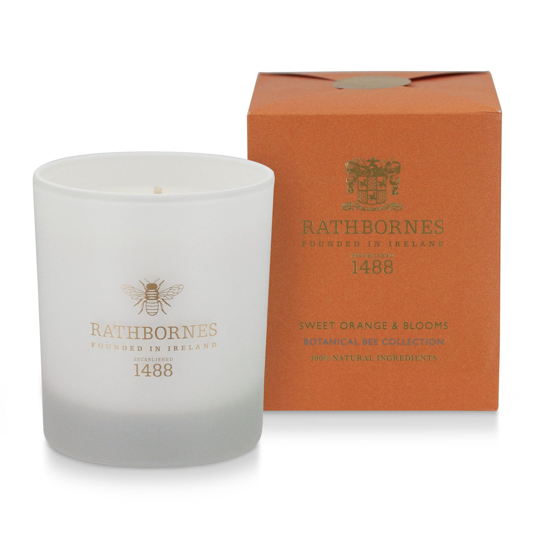 Rathbornes Sweet Orange & Blooms scented candle beside its burnt orange gift box