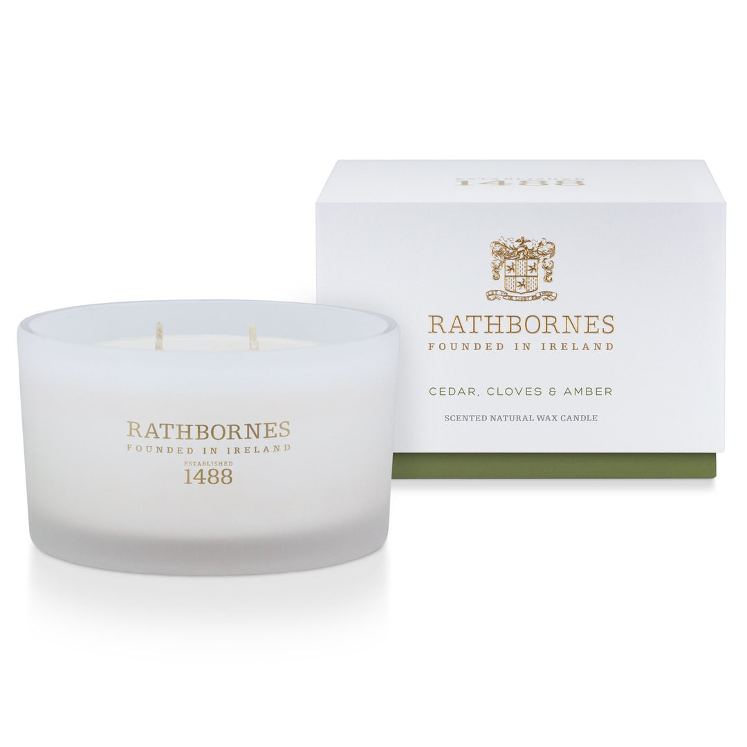 Rathbornes Cedar, Cloves & Amber luxury scented candle beside its white gift box with green base