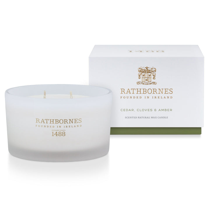 Rathbornes Cedar, Cloves & Amber luxury scented candle beside its white gift box with green base