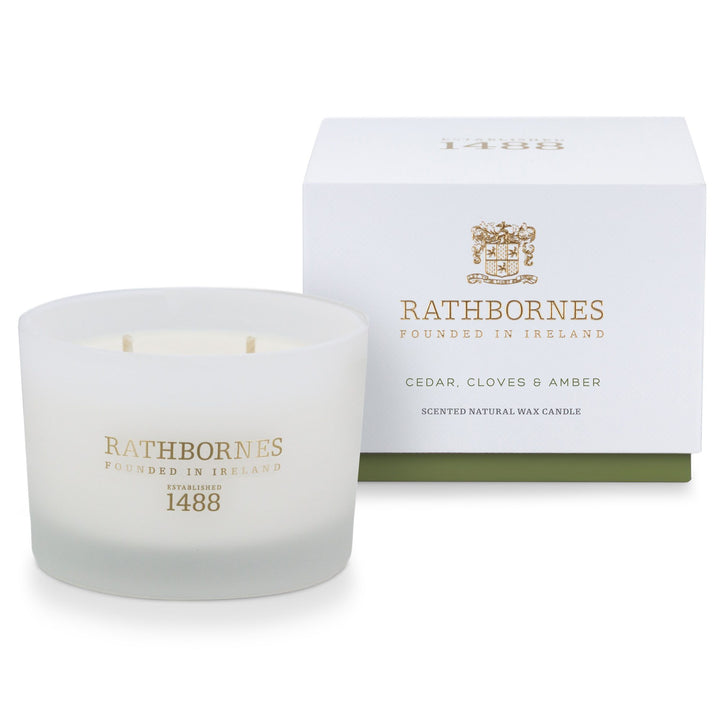 Rathbornes Cedar, Cloves & Amber classic scented candle beside its white gift box with green base