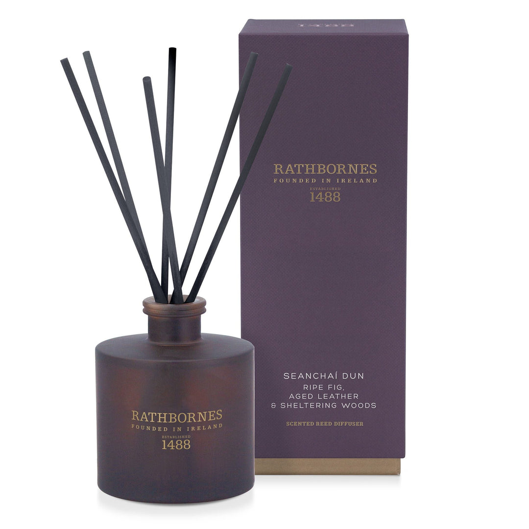 Rathbornes Seanchaí Dún (Ripe Fig, Aged Leather & Sheltering Woods) reed diffuser with reeds, beside its gift box