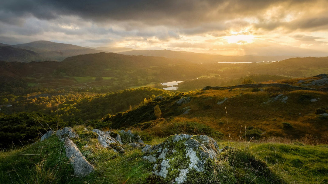 Sunlight breaking over green hills and lakes, the landscape that inspires Rathbornes candles